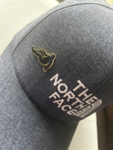 Bigfoot hat pin attached to black North Face hat